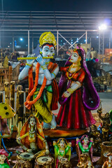 Naklejka premium Lord Krishna playing flute and Radha smiling lovingly, terracotta dolls made in Krishnanagar, Nadia, West Bengal, for sale in Handicraft Fair in Kolkata.