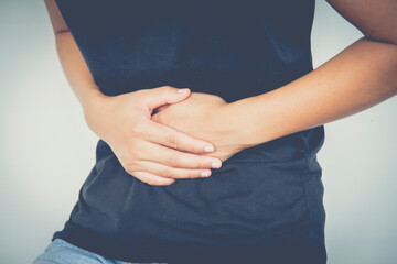 Woman having stomach ache, bending ,holding hands on belly