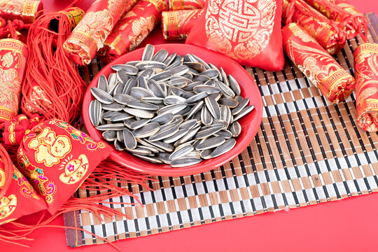 A plate of melon seeds surrounded by Chinese New Year decorations