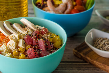 Hawaiian salmon, tuna and shrimp poke bowls with seaweed, avocado, mango, pickled ginger, sesame seeds. 