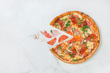 Italian meat Pizza with vegetables on white marble background with ingredients: bacon, salami, sliced tomatoes, champion mushrooms. Flying food concept. served with fresh parsley. Copy space

