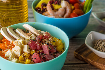 Hawaiian salmon, tuna and shrimp poke bowls with seaweed, avocado, mango, pickled ginger, sesame seeds. 