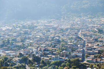 Obraz premium Aerial view of San Juan la Laguna in Lake Atitlan Guatemala in the morning - Small town surrounded by mountains and volcanoes with sunrise light.
