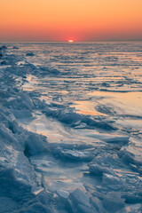 Sunset over the sea, which is covered with ice