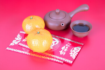 Tea set and red packets and oranges