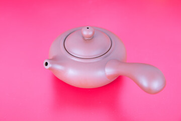 Purple clay pot with tea on red background