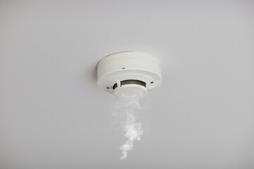 Smoke detector on white ceiling. Close up of smoke detector for fire protection systems. Selective focus.