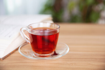 A cup of black tea and an open book