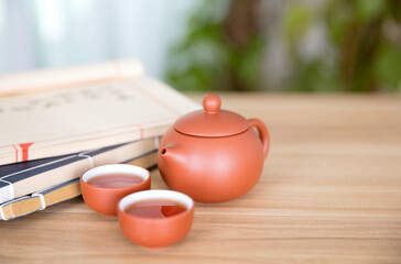 Shih Tzu milk pot and two bowls of tea and a few books