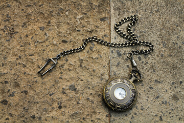 vintage pocket watch with zodiac engraving on a stone wall