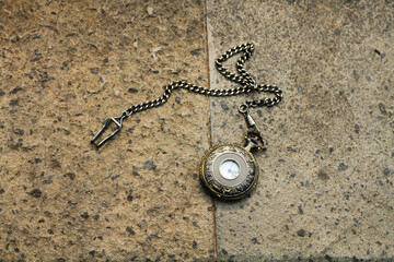 vintage pocket watch with zodiac engraving on a stone wall