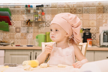 Little girl cooks at home in the kitchen