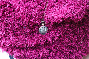 vintage pocket watch with tower engraving on purple scarf