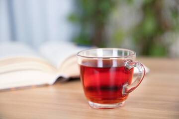 A cup of black tea and an open book