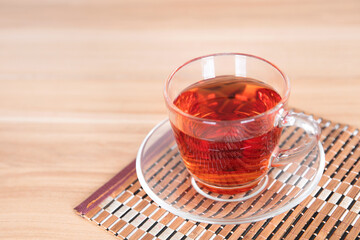 A cup of black tea on a bamboo mat