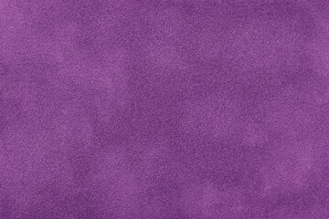 Fototapeta na wymiar Dark purple matte background of suede fabric, closeup. Velvet texture of textile