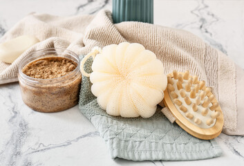 Sponge, bath accessories and cosmetics on table in bathroom