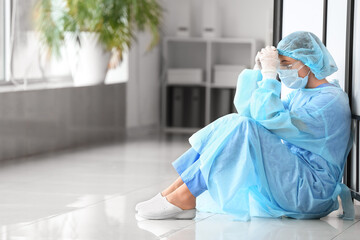 Portrait of depressed female surgeon in clinic