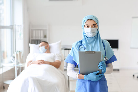 Portrait Of Female Muslim Doctor Wearing Protective Mask In Clinic