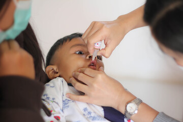 Nurse making infant oral vaccination against rotavirus infection. Children health care and disease prevention. - obrazy, fototapety, plakaty