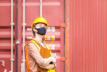 Engineer in hardhat and safety vest holding clipboard checklist and two-way radio, Woman wearing protection face mask against coronavirus at containers cargo