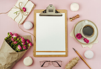 Obraz na płótnie Canvas Cup of coffee and Bouquet of spring flowers on trending pink paper.Clipboard with blank paper mockup. The concept of valentine's day and women's day.Flat lay, top view with copy space..
