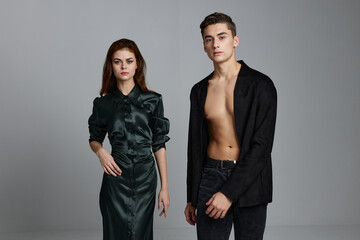 man in unbuttoned shirt and sexy woman on gray background portrait cropped view