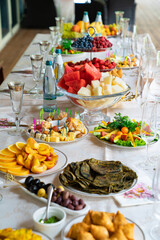 table served with light summer snacks-fruits, vegetables, berries. catering