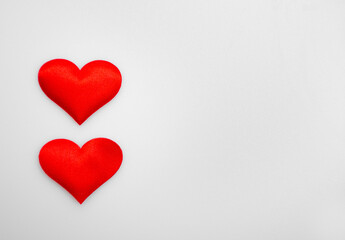 Two textured red hearts on top of each other on a white or gray background: place for text, St. Valentine's Day background, minimalism 
