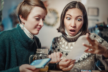 Asian woman stares at the check for dinner at the restaurant, her eyes bulging. The concept of...