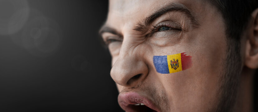 A screaming man with the image of the Moldavia national flag on his face