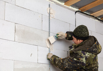A worker plasters the walls