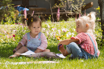 Two little girls sisters paint with finger paints