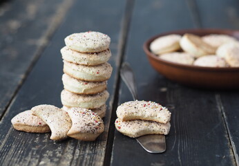 Ready-made homemade shortbread cookies, sprinkled with sugar, are placed in a stack on a dark wooden table.Confectionery background.