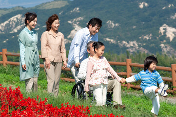 車椅子に座るシニア男性と笑顔の家族