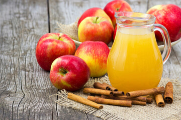 Apple juice and apples on wooden background