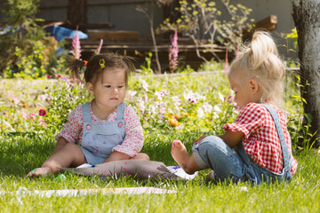 Two little girls sisters paint with finger paints