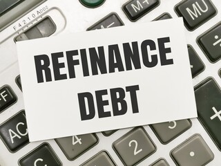 Text REFINANCE DEBT written on white paper note on calculator.Business concept.