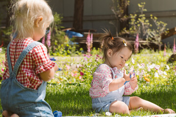 Two little girls sisters paint with finger paints
