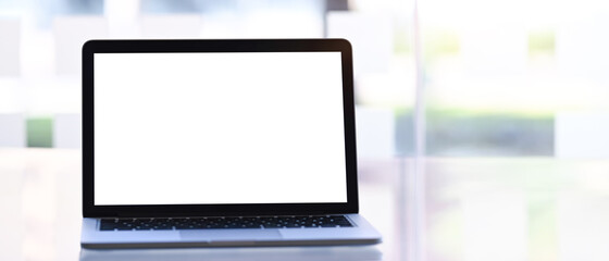 Mock up laptop computer with empty screen on white desk. White screen for advertising text.