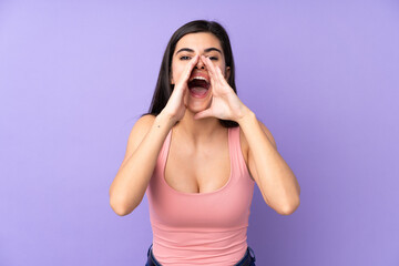 Young woman over isolated purple background shouting and announcing something