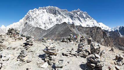 View from top of Chhukung hill over Lhotse wall with rock cairns in the foreground, Everest Base...