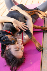 Fototapeta premium morning yoga concept with your pet. woman doing gymnastics with a beautiful doberman puppy in the morning park