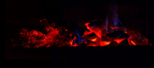 Fototapeta na wymiar Grill with hot coals and beautiful magic sparks with a blue flame