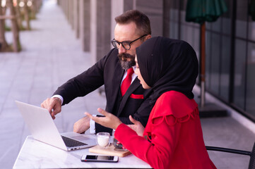 Muslim business woman wearing hijab and caucasian businessman, Marketing plan Market analysis With the future world business.