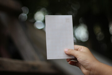 a hand holding a piece of blank paper for template