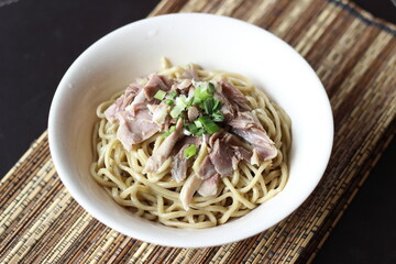 a bowl of noodle with white chicken meat slices