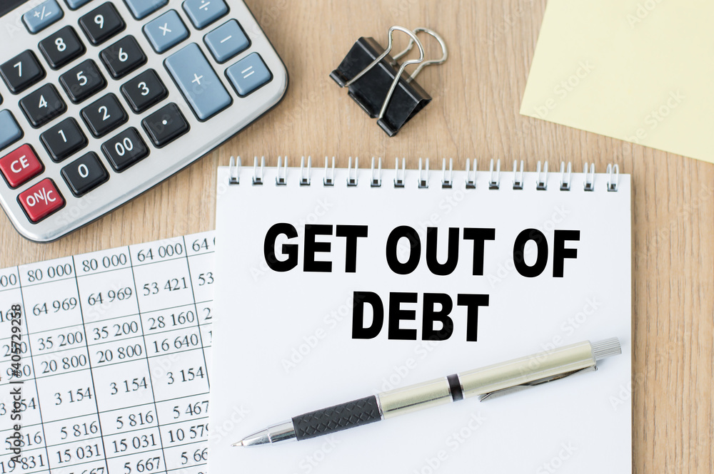 Poster notepad with get out of debt written on the desktop.