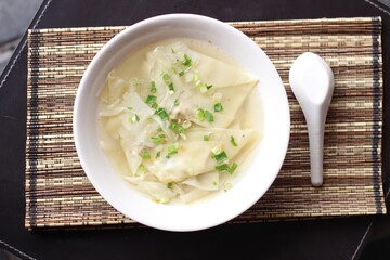 a bowl of dumplings with sweet clear chicken broth