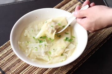 a bowl of dumplings with sweet clear chicken broth